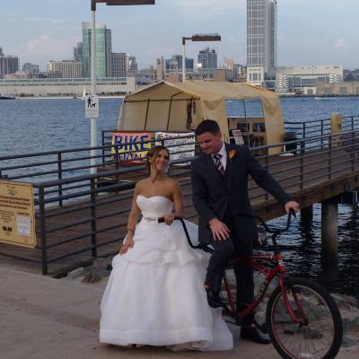 a couple of men riding on the back of a bicycle