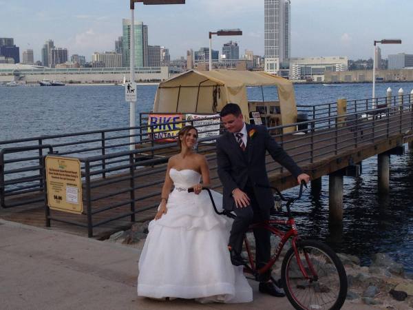 a couple of men riding on the back of a bicycle
