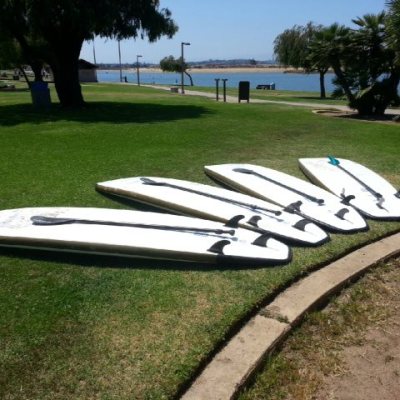a couple of lawn chairs sitting on top of a grass covered field