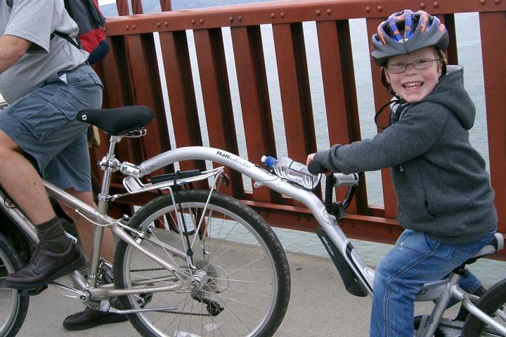 a young child riding on the back of a bicycle