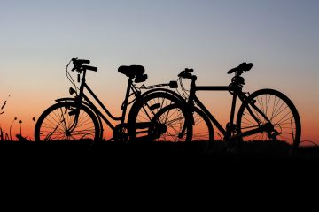 a bicycle parked in front of a sunset